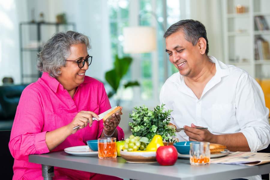 Indian woman and man sharing a healthy breakfast in a bright home.